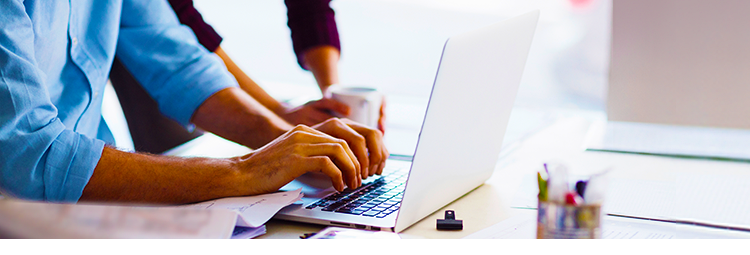 laptop computer in front of two hard-working business people