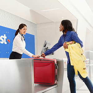 Image of young woman checking skis as luggage at the airport